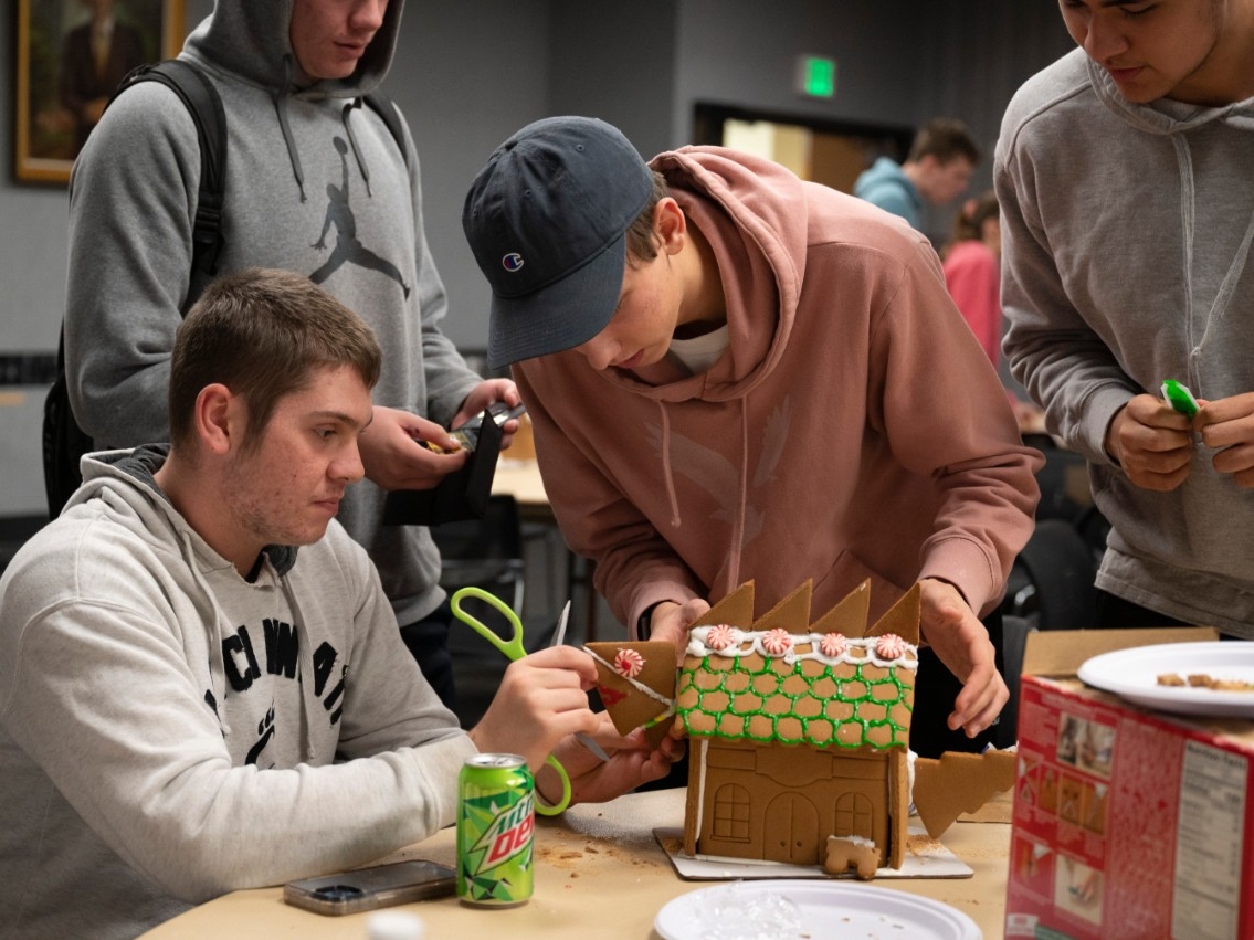 NKU STEM students having fun and being creative as they decorate gingerbread houses at the STEM Pizza Lunch.