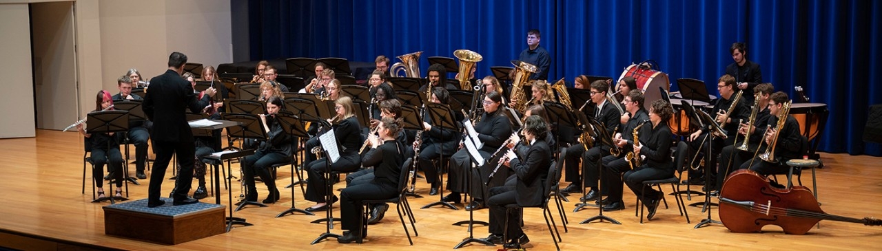 Conductor on stage with wind ensemble