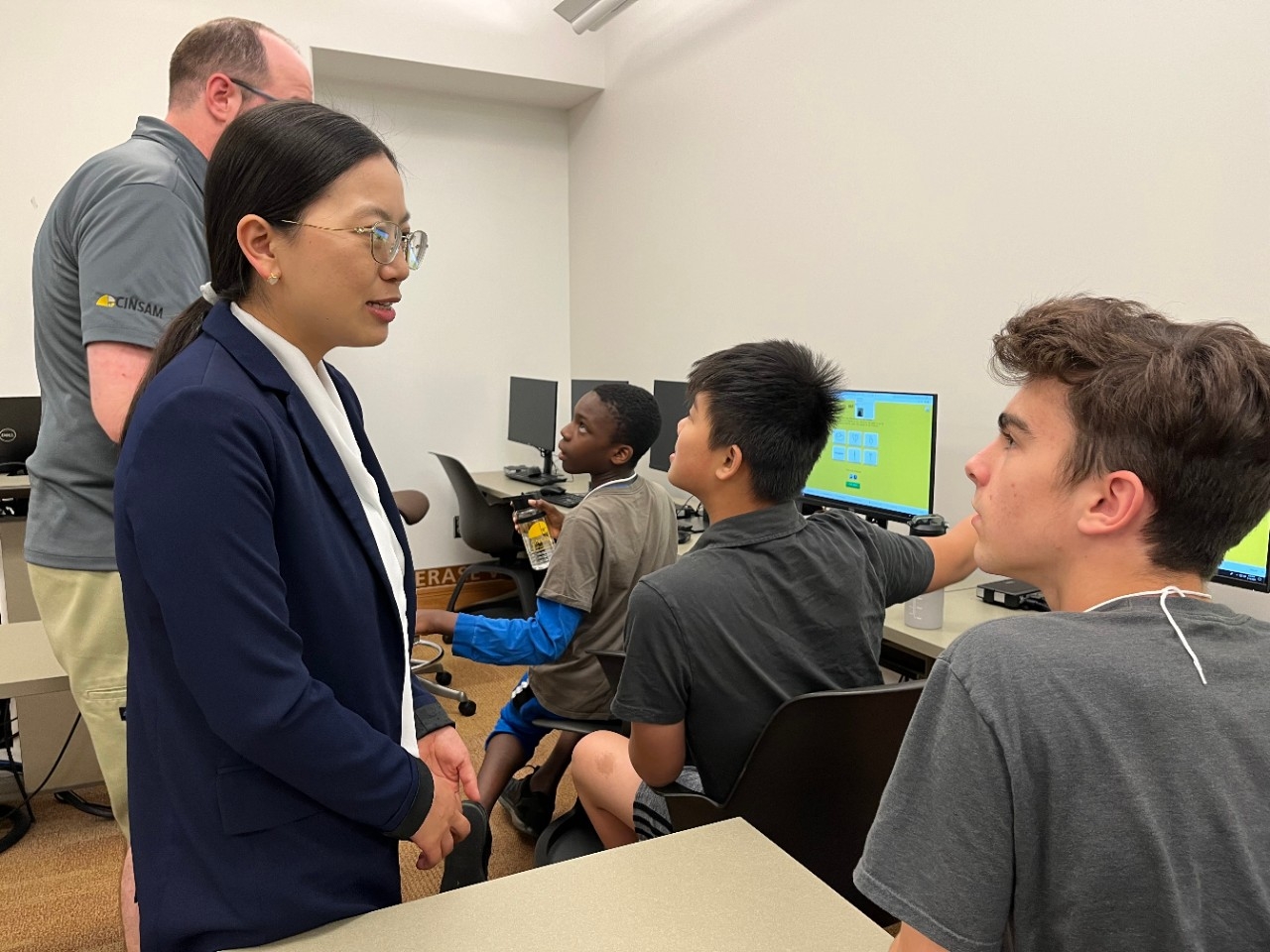 Unlocking the Future with AI Academy Teens intently talk to AI professionals while doing computer activities