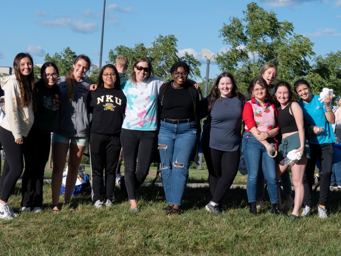 A group of NKU STEM students smiles for the camera at the STEM Tie-dye event.