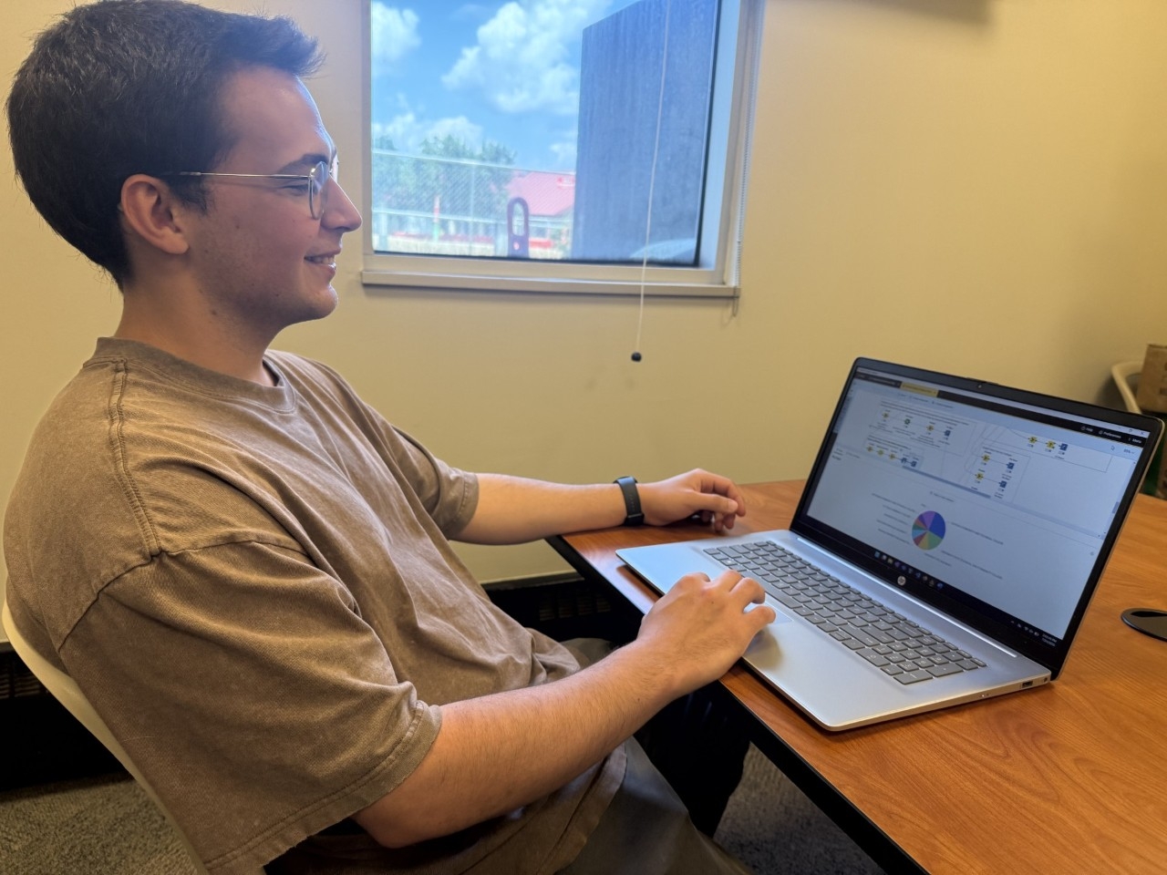 NKU Computer Information Technology major scrolls through his research presentation on a computer.