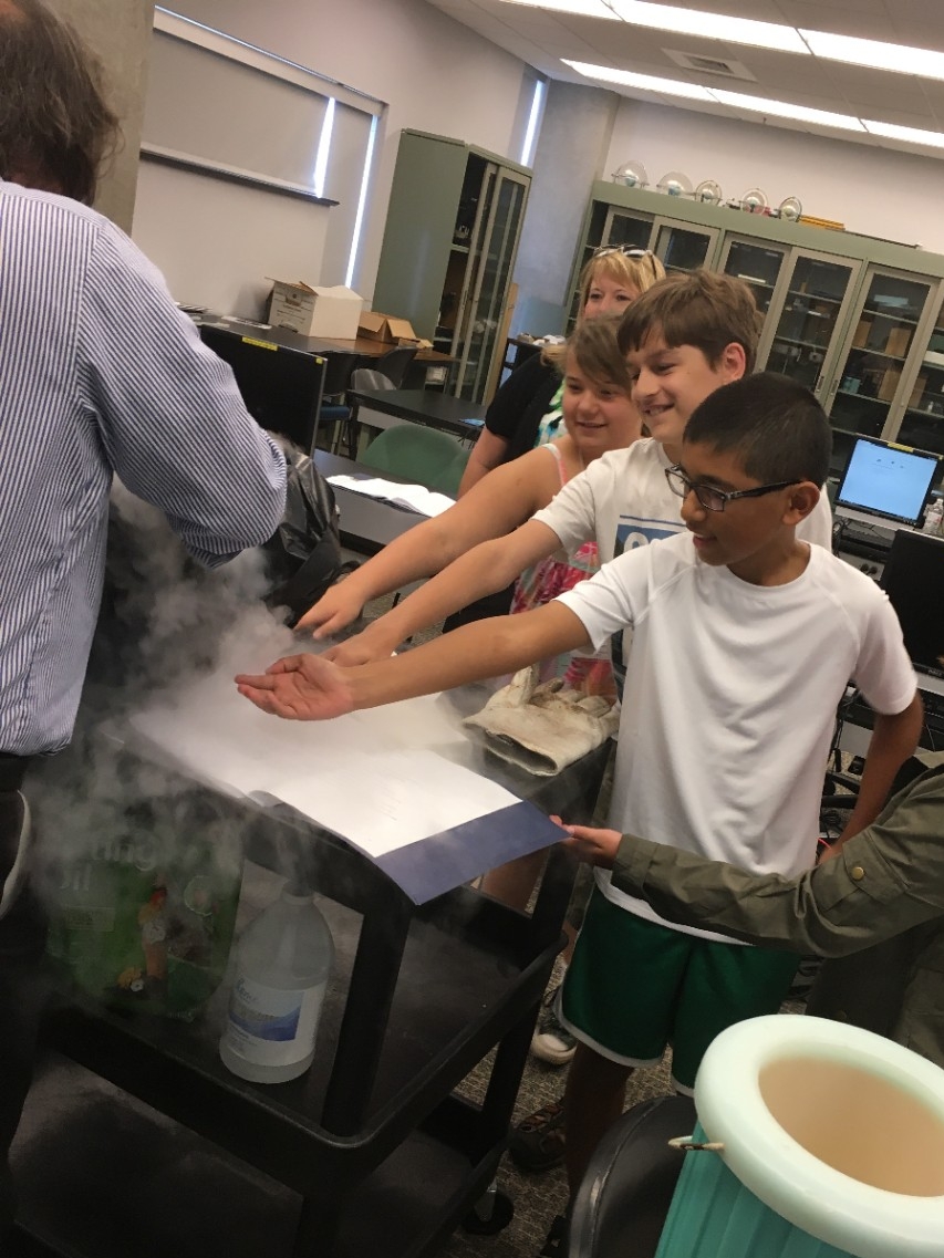 School-aged camp participants enjoying a science experiment lead by a NKU faculty member