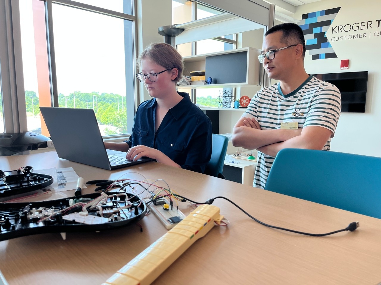 Student researcher and a faculty member doing computing and analytics research in sunny room