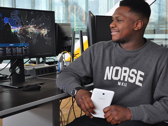 NKU student smiling while working at a computer