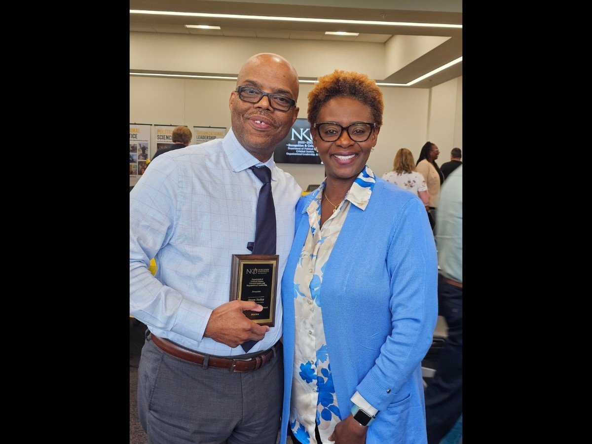Anson Turley holding his award plaque with Nana Arthur-Mensah (Organizational Leadership professor)