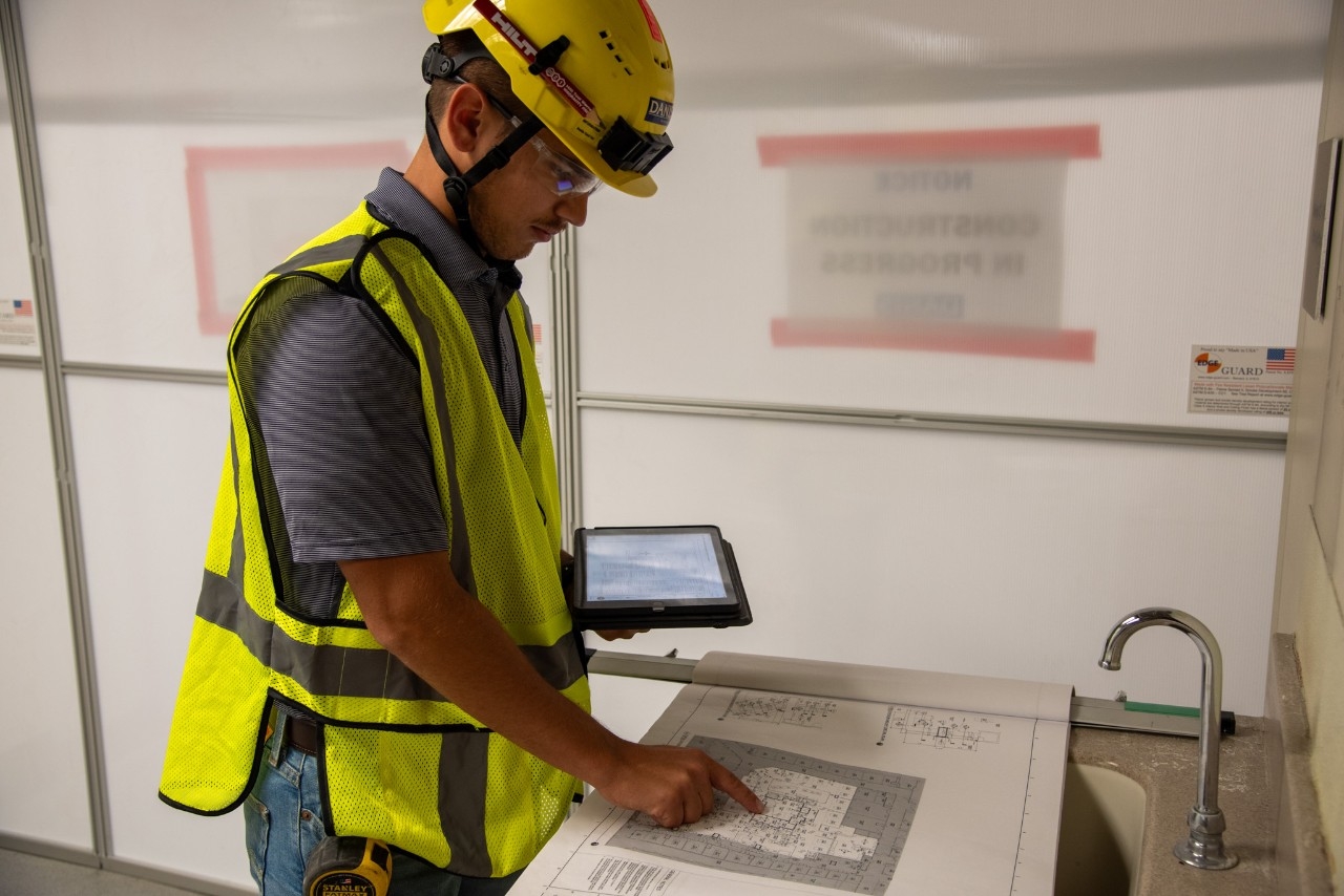 Construction management student studying a blueprint.