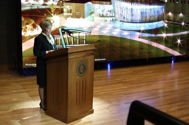 woman at podium in front of screen