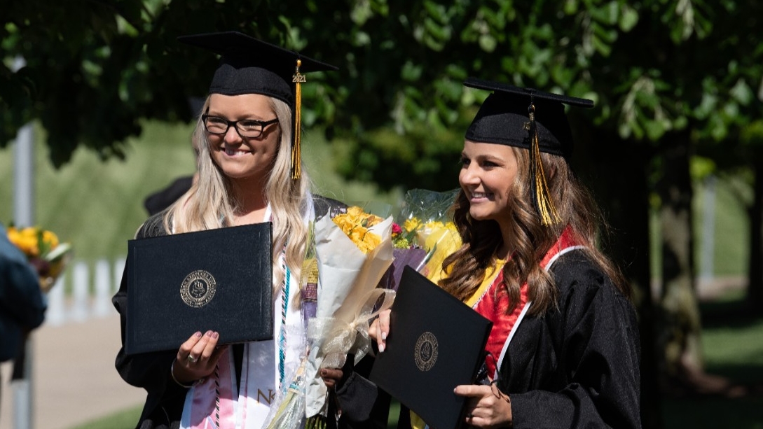 Female students posing with their degrees