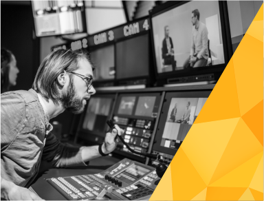COI media communications image with a student looking at multiple broadcast monitors and a decorative yellow angle in the lower right corner