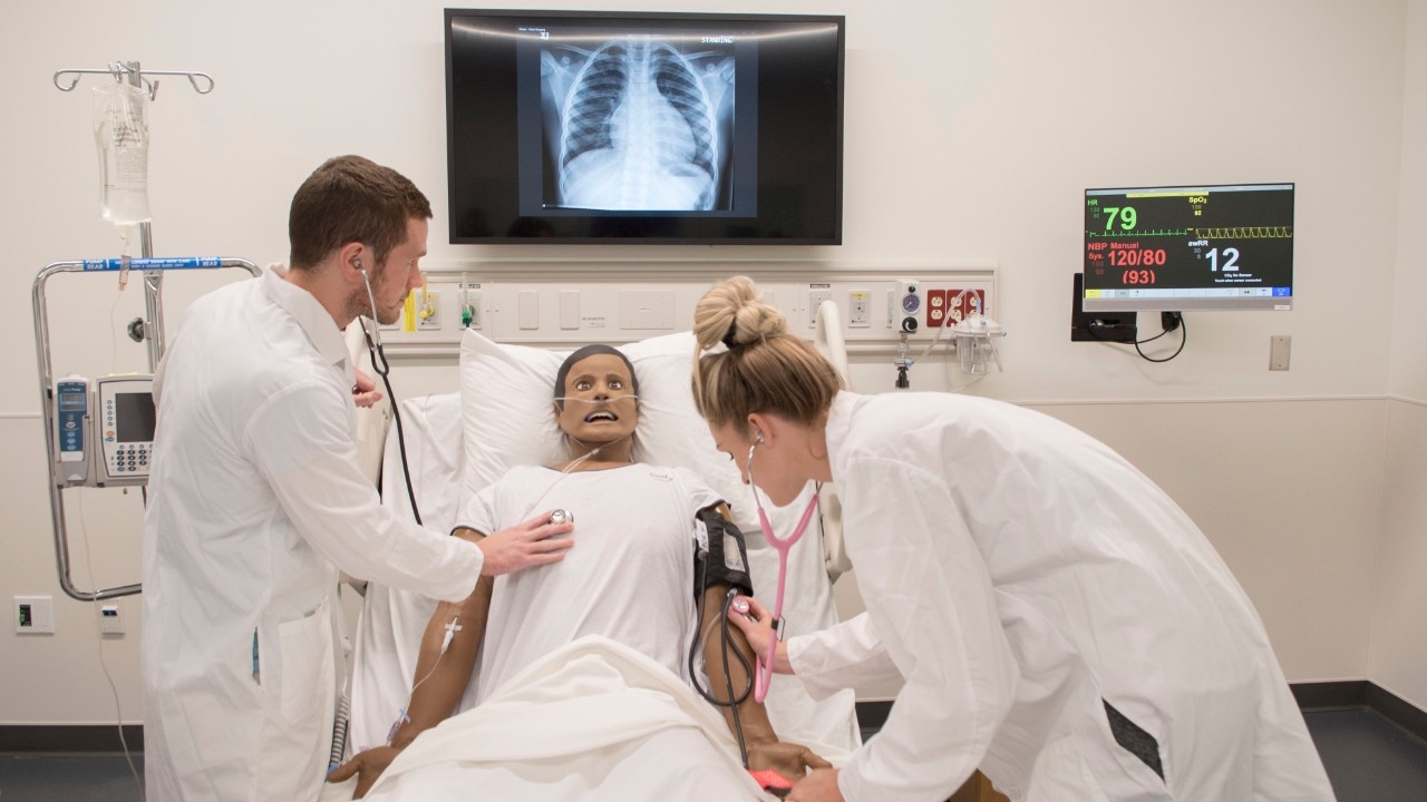 Medical students examine an inpatient simulation