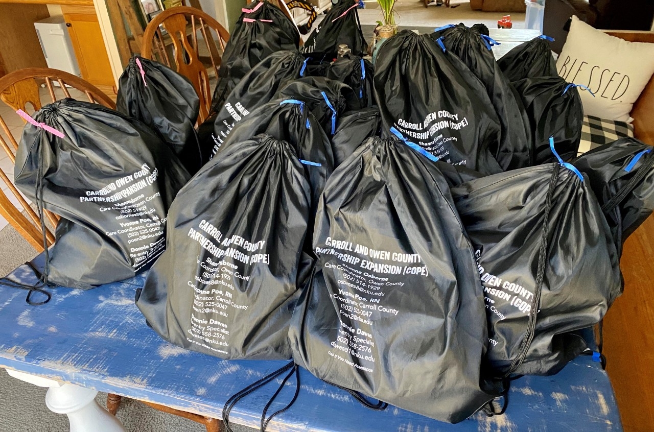 Black drawstring bags with resource information.