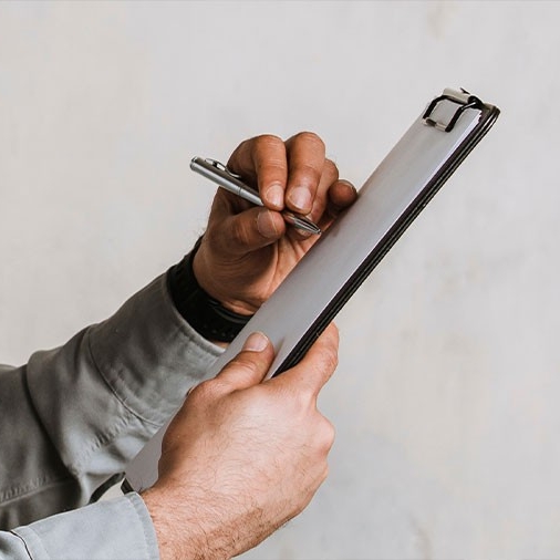 Hands holding a clipboard and a pen