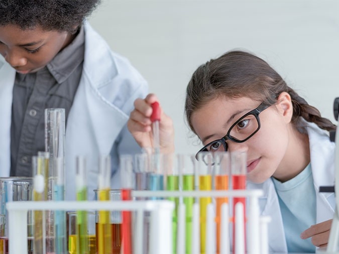 young scientist making experiments in glass tube in the laboratory room