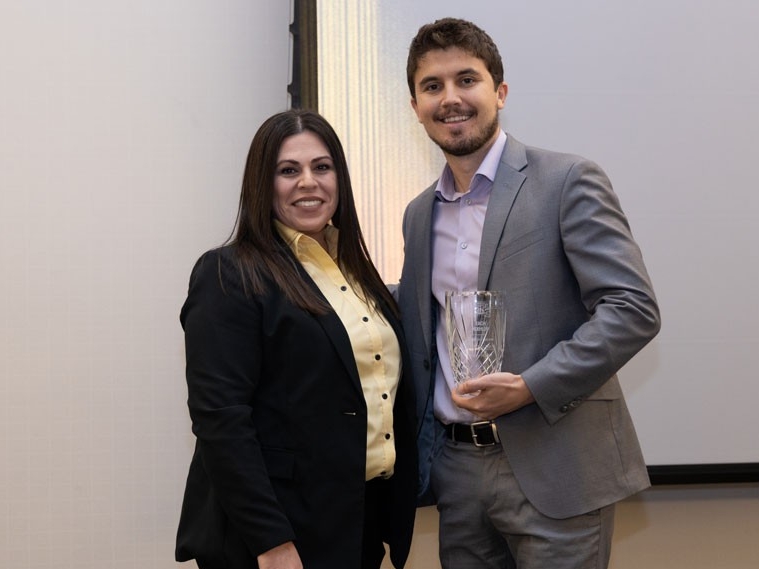 Zach Koehler holding award with Christina Roybal