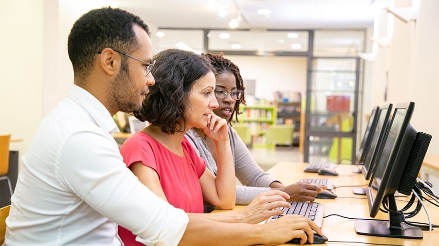 People helping another use a computer