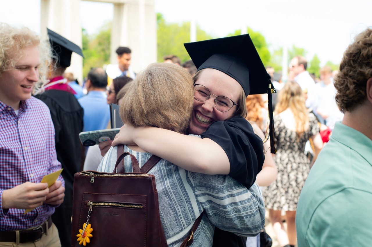 Student hugging their family after graduating
