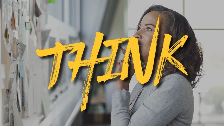Businesswoman reading bulletin board in office - the word Think is superimposed