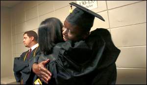 Kpandja Djawe hugs a friend while waiting for the graduation ceremony to begin Friday at U.S. Bank Arena. Djawe, 29, is from Togo.